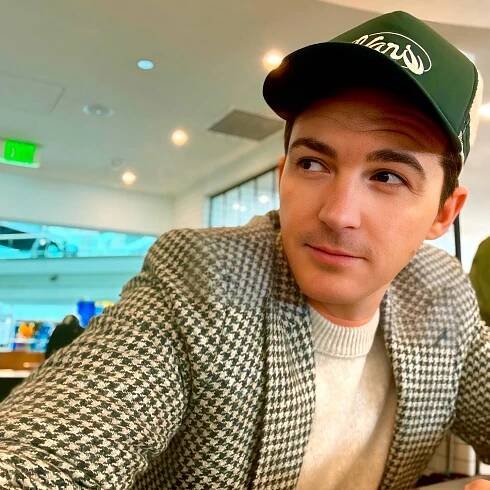Drake Bell in a green hat.