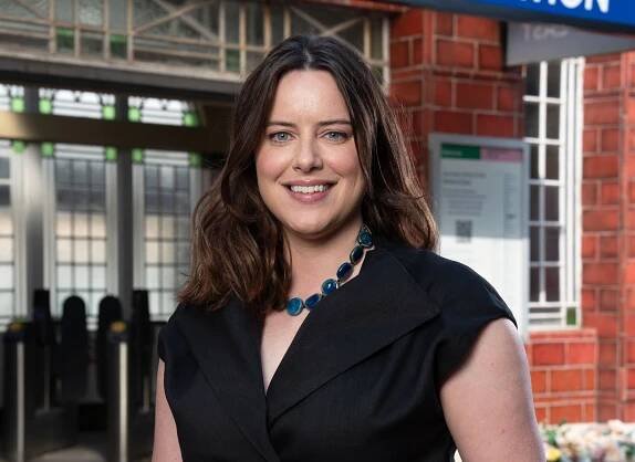 Michelle Ryan smiling as EastEnders character Zoe Slater outside Walford East Tube station.