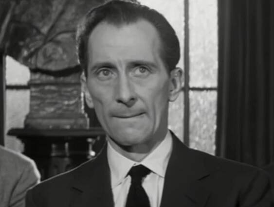 Screenshot of Peter Cushing wearing suit and looking at side - from Cone of Silence (1960)
