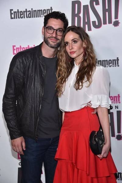 Tom Ellis and Meaghan Oppenheimer in White Top and Red Skirt