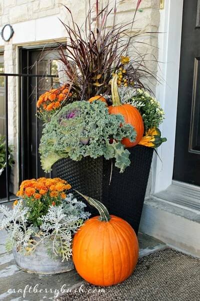 two pumpkins are sitting on the front porch