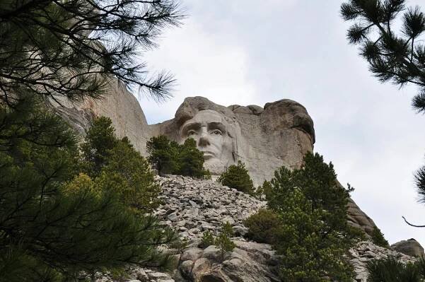 bezplatná Dramatický pohled na Abrahama Lincolna na Mount Rushmore obklopeném přírodou. Základová fotografie