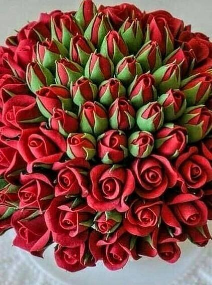 a bouquet of red roses sitting on top of a table