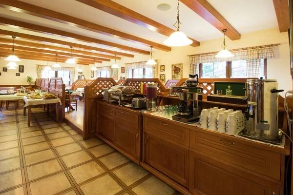 a restaurant with a counter with a coffee shop at Hotel České Žleby in Stožec