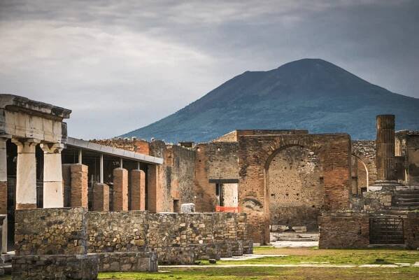 Sopka Vesuv tyčící se nad ruinami starověkých Pompejí, ikonický pohled na historii a přírodní sílu.