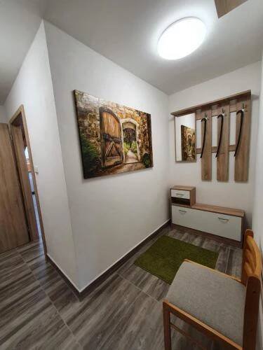 a living room with a table and a painting on the wall at Apartmány Nová duha Vavřinec in Vavřinec