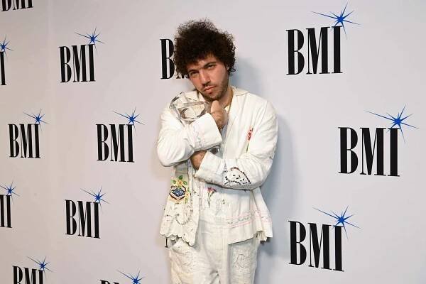 Benny Blanco posing at a BMI event, standing with arms crossed wearing a patterned outfit
