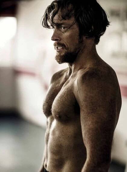 a man with no shirt standing in a room