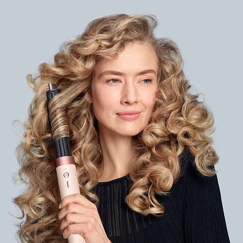 Blond modelka si natáčí vlasy pomocí multistyleru a vysoušeče Dyson Airwrap Co-anda2x s 30mm nástavcem Co-anda2x.