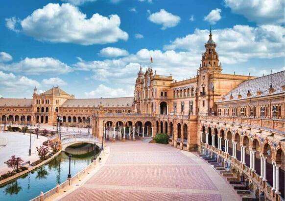 The majestic Plaza de España in Seville with its semicircular architecture and bridges.
