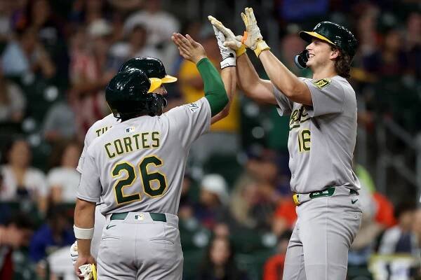 Nick Kurtz #16 of the Athletics is congratulated by Carlos Cortes #26 and Colby Thomas #32 after hitting his fourth home run of the game in the ninth inning against the Houston Astros at Daikin Park on July 25, 2025 in Houston, Texas.