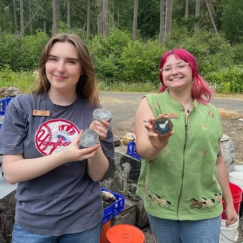 Two interns holding agate geode specimens.