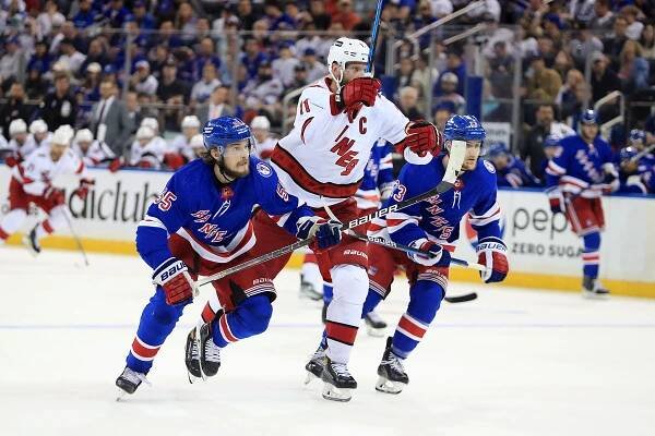 Carolina Hurricanes center Jordan Staal (11) tries to skate between New York Rangers defenseman Adam Fox (23) and New York Rangers defenseman Ryan Lindgren (55) during the third period in game three of the second round of the 2022 Stanley Cup Playoffs at Madison Square Garden.