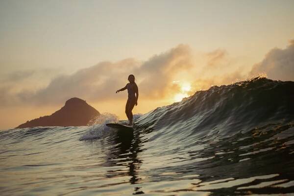 a man riding a wave on top of a surfboard