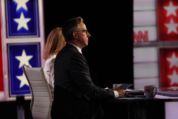 Jake Tapper and Dana Bash sit at a desk during a presidential debate hosted by CNN.