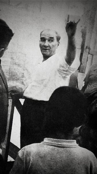 an old black and white photo of two men standing next to each other with their hands in the air