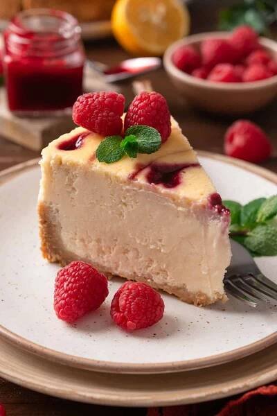 a slice of raspberry cheesecake - on a plate.