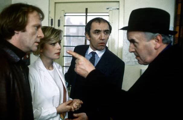 Still from the TV show *Minder*, featuring Dennis Waterman, Nicola Cowper, and George Cole.
