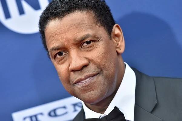 Denzel Washington posing in a suit at the American Film Institute's 47th Life Achievement Award Gala Tribute.