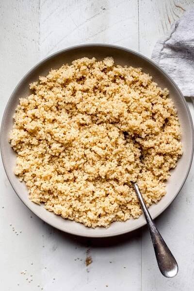 Overhead shot of bowl of fluffy quinoa with spoon.