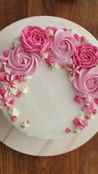 a white cake topped with pink frosting roses