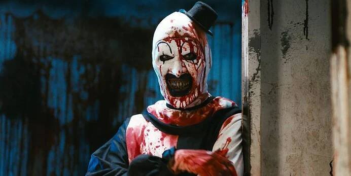 A bloody Art leans against a wall in Terrifier 2