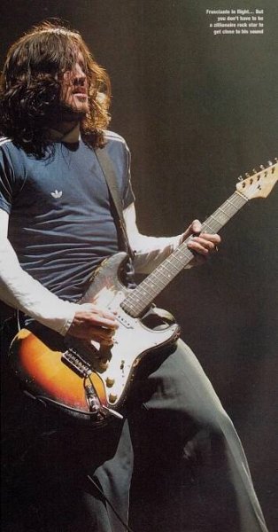 a man with long hair playing an electric guitar