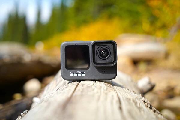 GoPro HERO9 Black action camera on a log.