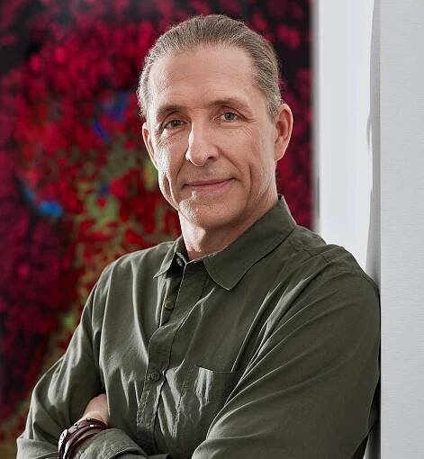 Dave Asprey arms crossed, wearing a navy green shirt