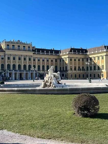 Elegant fountain at Schloss Schönbrunn in Vienna, Austria, featuring classical sculptures and flowing water set in the palace’s formal gardens with the grand Baroque façade in the background.