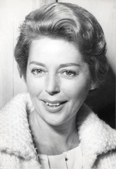 an old black and white photo of a woman with short hair wearing a sweater jacket