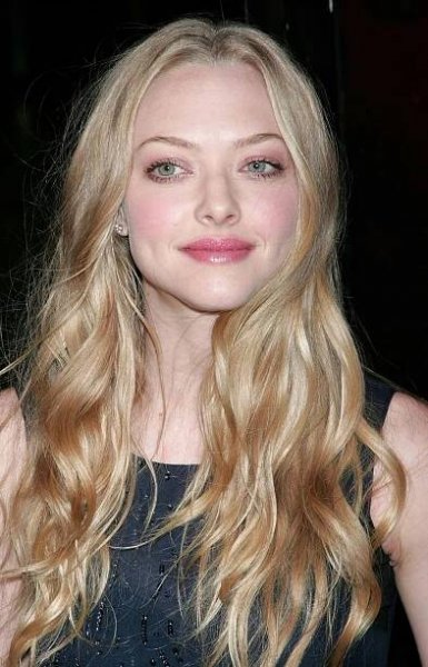 a woman with long blonde hair wearing a black dress