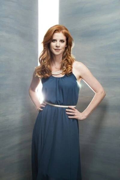 a woman in a blue dress is posing for a photo with her hands on her hips