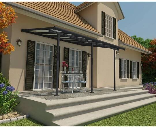Graue Palram Sierra Terrassenüberdachung (434x295cm) am Haus mit Tisch und Stühlen.