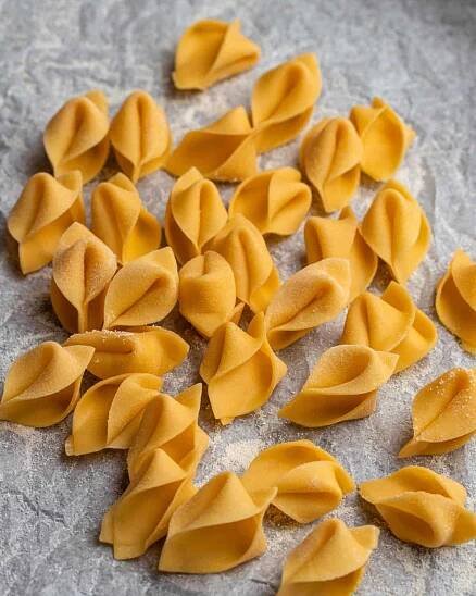Sorpresine pasta on a baking tray lined with parchment paper.