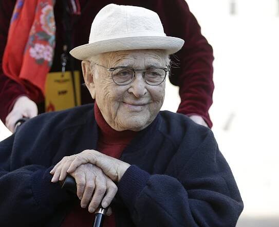 Norman Lear wearing a white hat and glasses