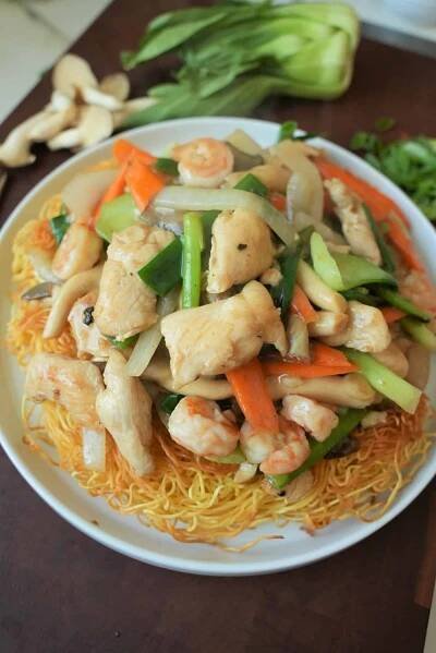 a white plate topped with noodles and chicken