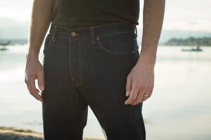 Photograph of a man wearing a pair of bespoke Thread Theory jeans. We see only a third of his body, focusing on the waist line.