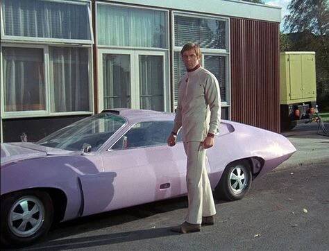 a man standing in front of a pink car