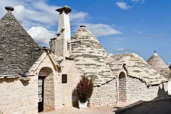 bezplatná Krásné trulli domy pod jasnou modrou oblohou v Alberobello, Apulie, Itálie. Základová fotografie