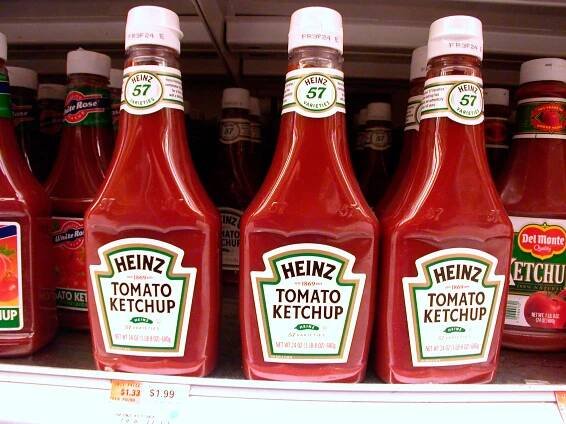 Bottles of Heinz tomato ketchup on a supermarket shelf.