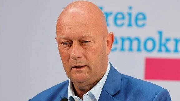Thomas Kemmerich steht an einem Mikrofon