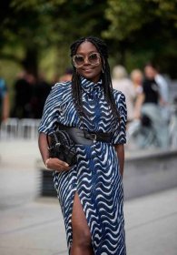Lois Opoku wears a printed summer dress and a black statement belt, one way to style a statement belt for 2023.