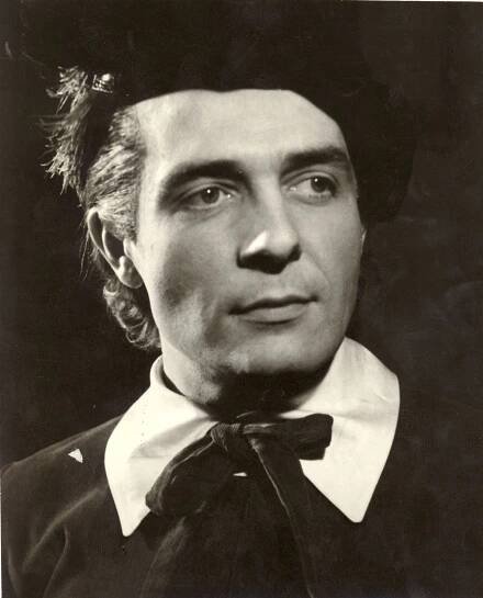 an old black and white photo of a man wearing a top hat with his hair pulled back