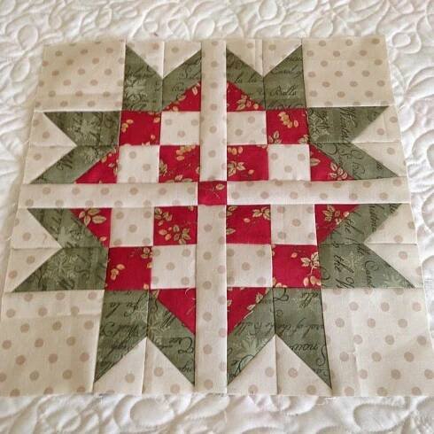 a red and white quilted christmas ornament sitting on top of a bed