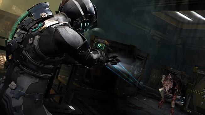 Issac Clarke firing plasma bolts at a necromorph that is rushing towards him inside a space station office.