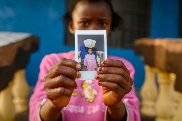 Little girl holding polariod, slowfood international,sierra leone street photography