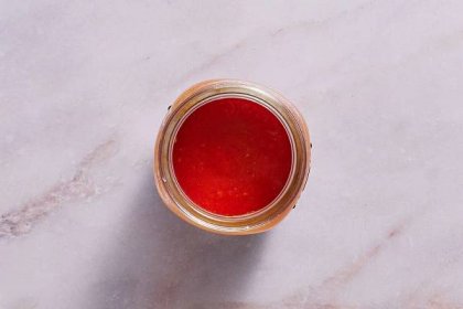 A jar of tomato puree with space at the top