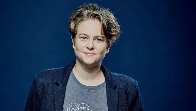Photo of Emily Howard against a blue background
