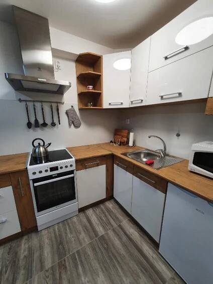 a kitchen with white cabinets and a stove top oven at Apartmány Nová duha Vavřinec in Vavřinec